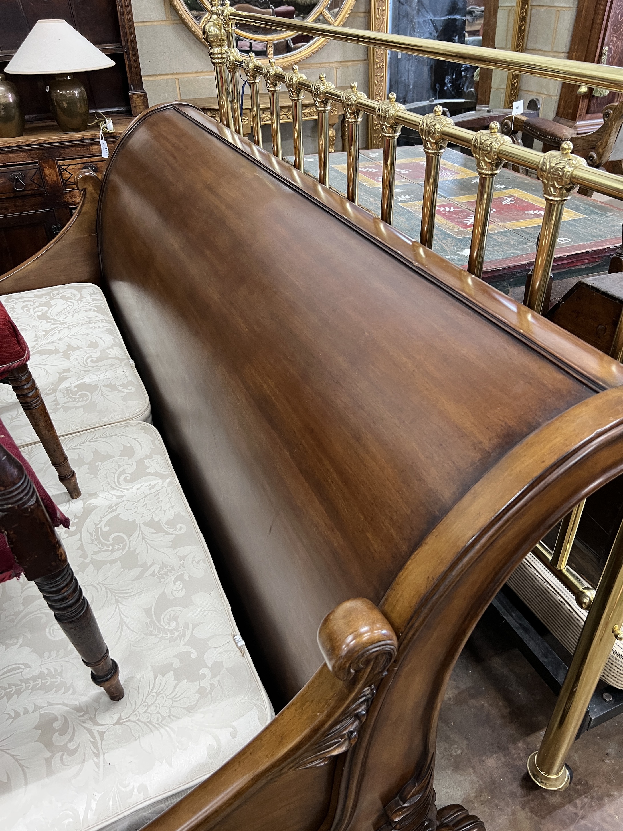 A good mahogany Superking sleigh bed by And So To Bed, London. Handmade copy of the Brodsworth bed, at Brodsworth Hall, South Yorkshire, with carved Lion's feet and scrollwork ends, with a Sienna veneer and hand-polished